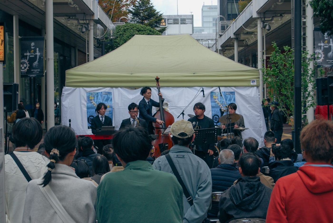 一番町四丁目商店街の三越前に設けたステージで演奏するバンドと、それを囲む人たち